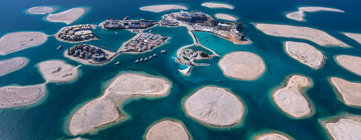 Aerial view of The World Islands Dubai with mainland skyline on the horizon