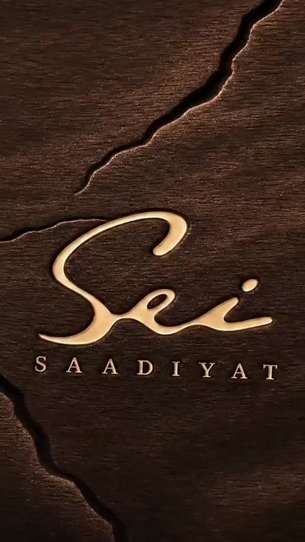 Gold Sei Saadiyat 2 wordmark engraved on dark wood for residences on Saadiyat Island, Abu Dhabi