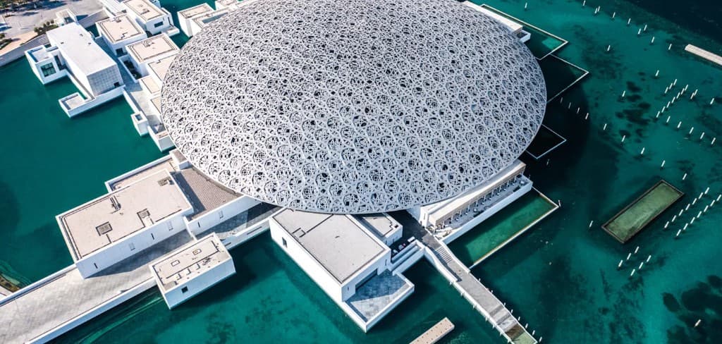 Louvre Abu Dhabi museum dome on Saadiyat Island waterfront beside Sei Saadiyat by Aldar in Saadiyat Cultural District, Abu Dhabi — reference institutional imagery